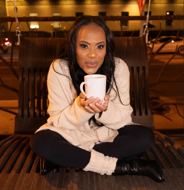 Rosa Allison seated with a cup of coffee